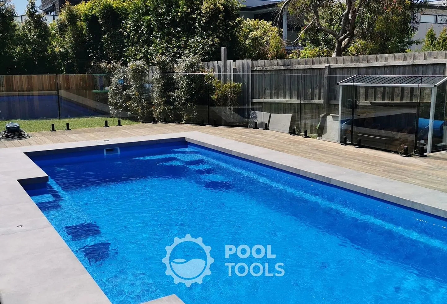 Blue pool with 'Pool Tools' logo in a backyard setting