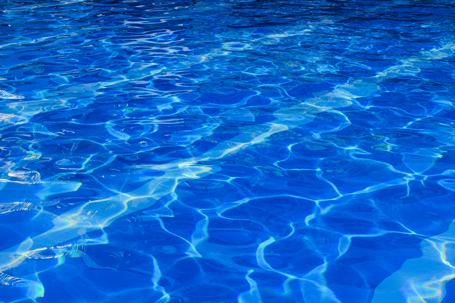 Ripples on a clear blue pool water surface