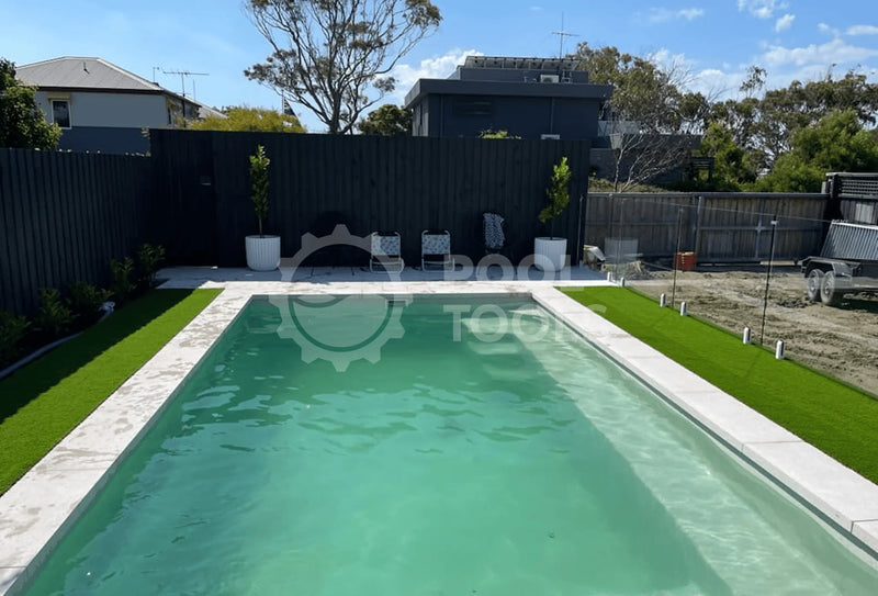 Pool Tools project - Rectangular pool with green water in a backyard setting with grass and a fence.