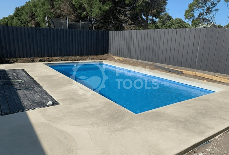 Pool Tools project - Rectangular pool with blue water in a backyard setting, surrounded by a fence