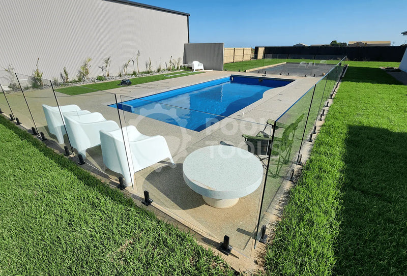 Pool Tools project - Outdoor pool area with lounge chairs and a table on a sunny day.