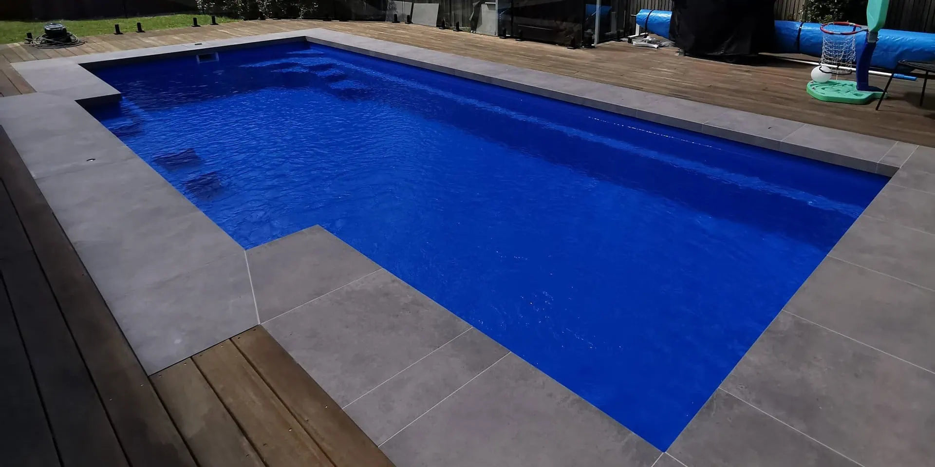 Pool Tools project - Rectangular pool with blue water, concrete deck, and grassy area in the background